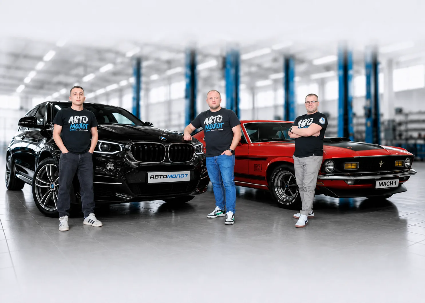 Команда АВТОМОЛОТ: мастера в фирменном мерче рядом с BMW и Ford Mustang в цехе